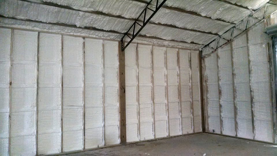 Closed-cell spray foam insulation across the interior walls and ceiling of a Marianna building